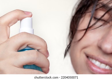 Woman Using Spray On Wet Hair Isolated.smiling Girl With Wet Hair Long Bangs Chaotic On Face Hold In Hand Bottle With Oil Spray Keratin For Extra Shine Healthy Structure.parts Of Face Closed Eye Relax