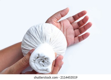 woman using steamed thai herbal compresses to relieve pain and reduce swelling in wrist.herbal compress ball for thai massage 