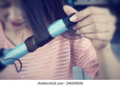 Woman Using Straightener With Hair