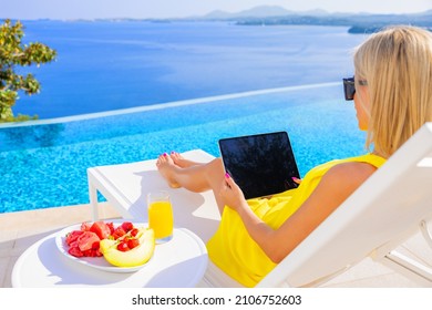 Woman Using Tablet By Infinity Pool