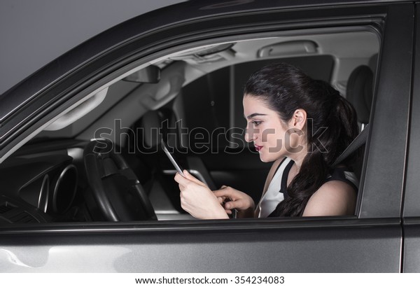 woman using tablet in\
car looking happy
