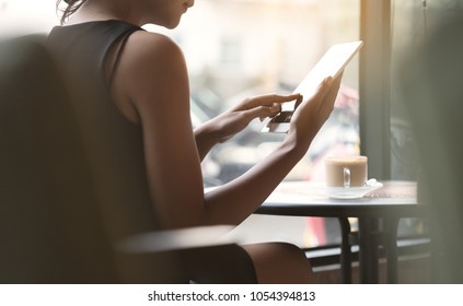 Woman Using Tablet In Coffee Shop