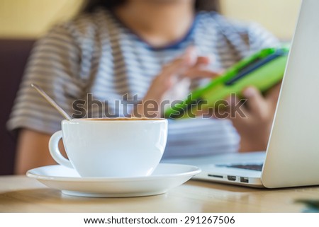 Woman using tablet computer in cafe on coffee break