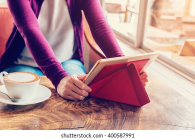 woman using tablet computer in coffee shop with vintage tone.
