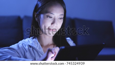 Woman using tablet computer at night 