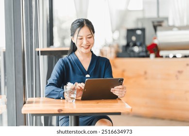 A woman using tablet in cozy cafe setting, enjoying her time. - Powered by Shutterstock