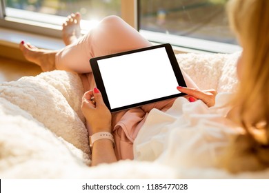 Woman using tablet at home in living room. Mockup for your own content.