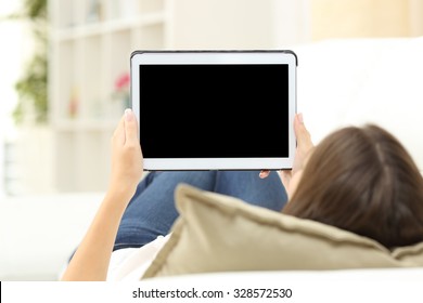 Woman Using A Tablet And Showing A Blank Screen Lying On A Couch At Home