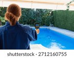Woman using thermal camera checking pool leak detection