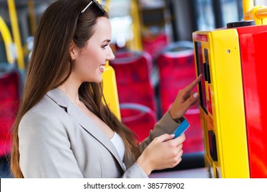 Woman Using Ticket Machine On Bus
