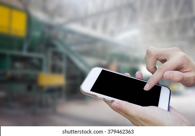 Woman Using Touch Screen Mobile Phone With Old Factory Garbage,Waste Recycling Plant