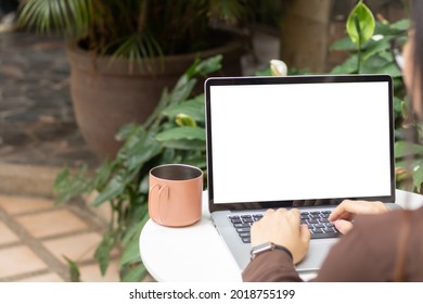 Woman Using Or Typing Laptop Outside Cafe Restaurant With Natural. Laptop Computer On White Desk And White Blank On Screen.