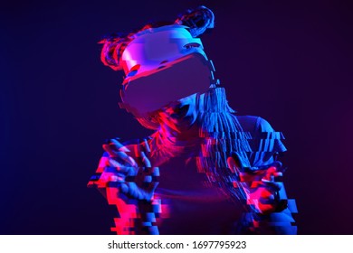 La mujer está usando auriculares de realidad virtual. Retrato Neon light studio. Concepto de realidad virtual, simulación, juego y tecnología futura. Imagen con efecto de fallo.