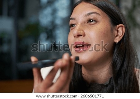 A Woman Using Voice Command on a Smartphone in a Modern Environment