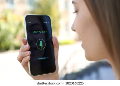 Woman Using Voice Search On Smartphone Outdoors, Closeup