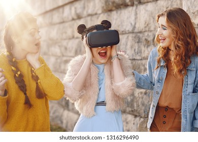 Woman Using VR Headset Glasses 360, VR Experience Outdoor. Visual Reality Concept.  Excited Three Girls Experiencing Virtual Reality. Grup Of Girl Having Fun Together  With New Technology, Smile. Sun.