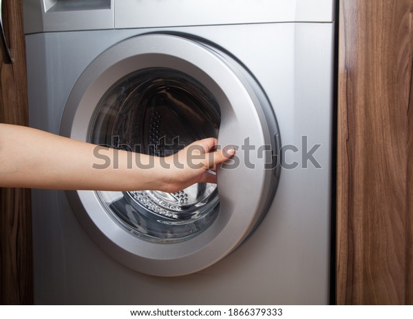 \
Woman using washing machine. Washing machine at\
home.
