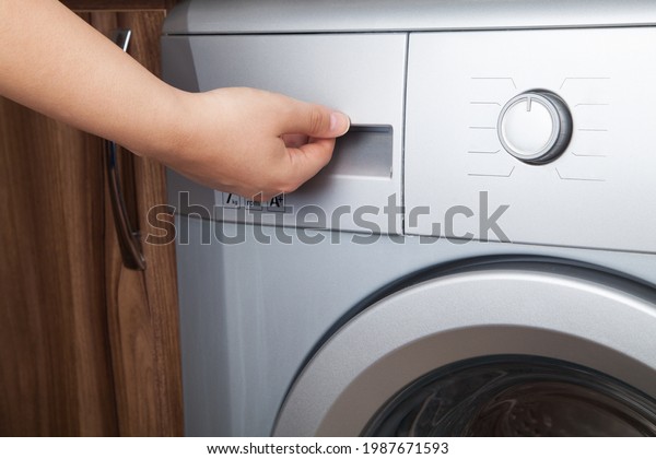 \
Woman using washing machine. Washing machine at\
home.
