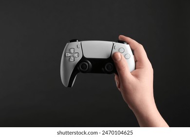 Woman using wireless game controller on dark background, closeup