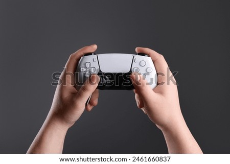 Woman using wireless game controller on dark background, closeup