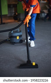 Woman Vacuuming The Floor With A Canister Vacuum Cleaner