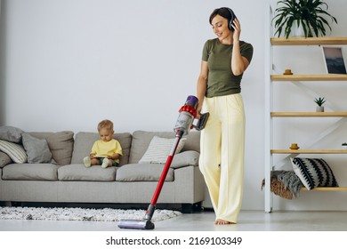 Woman vacuuming the house while little son sitting on sofa - Shutterstock ID 2169103349