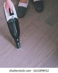 Woman Is Vacuuming Pet Hair From A Hardwood Floor With A Cordless Portable Vacuum Cleaner