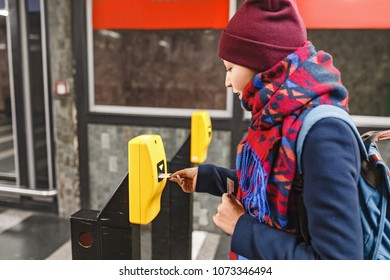 Woman validate ticket in validating machine device to entering at metro station in Prague