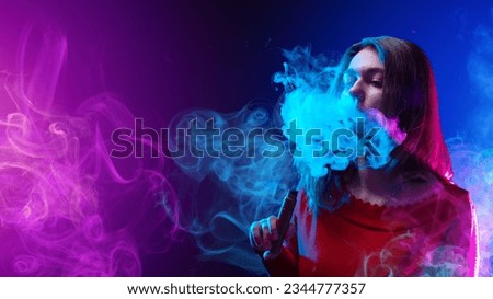 Woman vaper. Girl with electronic cigarette. Young woman smokes vape. Vaper blows smoke from nose. Girl with vaping device. Young lady vaper on purple. Vaping hobby. Vape as alternative to tobacco