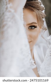 A woman with a veil over her face is wearing a white dress