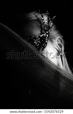 Woman with venetian mask. Black and white studio shot.