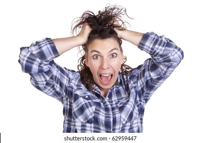 A woman is very frazzled with her hands in her hair.
