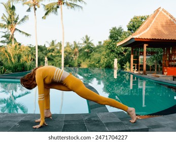 Woman in vibrant yellow outfit practicing yoga poolside in beautiful bali, indonesia - Powered by Shutterstock