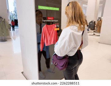 Woman viewing advanced mirror display in retail store showing personalized offers to customers - Powered by Shutterstock