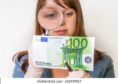 Woman Viewing Counterfeit Euro Banknote With Magnifying Glass