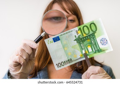 Woman Viewing Counterfeit Euro Banknote With Magnifying Glass