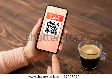 Woman viewing discount coupon on her mobile phone
