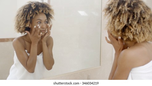 Woman viewing herself in the mirror in the bathroom