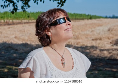 Woman Viewing Solar Eclipse With Solar Glasses In Country Field