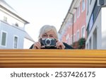 Woman with vintage camera capturing urban street moments in colorful neighborhood