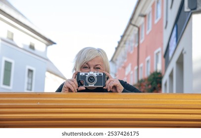 Woman with vintage camera capturing urban street moments in colorful neighborhood - Powered by Shutterstock