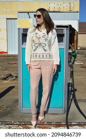 Woman In Vintage Outfit In Front Of A Vintage Gas Pump