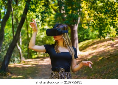 Woman With Virtual Reality Glasses Enjoying Nature Seeing Things In The Glasses