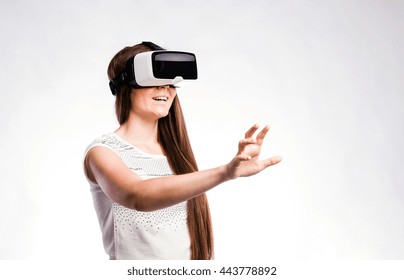 Woman with virtual reality goggles. Studio shot, gray background