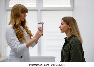 Woman Visit Neurologist. Doctor Testing Eye Reflex With Hammer