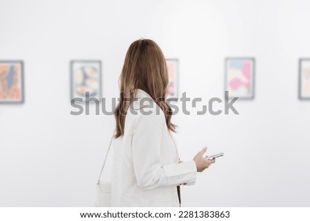 Woman visiting art gallery her looking pictures on wall watching photo frame painting at artwork museum people lifestyle concept.