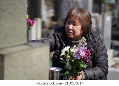 A woman visiting a grave
 - Shutterstock ID 2150170017