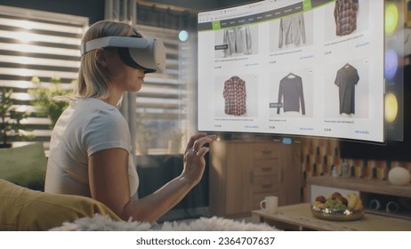 Woman in VR headset chooses clothes in online store chilling at home. 3D futuristic hologram shows widgets in user menu and clothing store website interface. VFX animation. Concept of online shopping. - Powered by Shutterstock