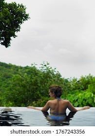 Woman Wading In An Infinity Pool