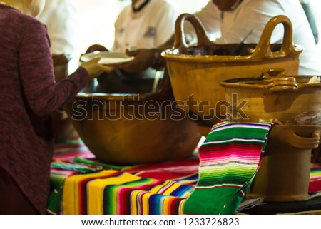 
A woman waiting for her food at a mexican restaurant, in the restaurant big mexican handmade clay pots and saltillo colorful